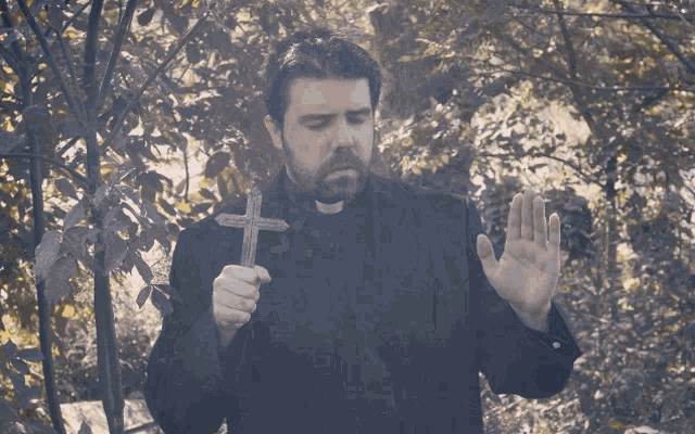priest-praying-with-cross-k8kuekqmscg9ub4v.gif